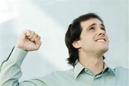 Man clenching fist, looking up, portrait Stock Photo - Premium Royalty-Free, Code: 696-03394046