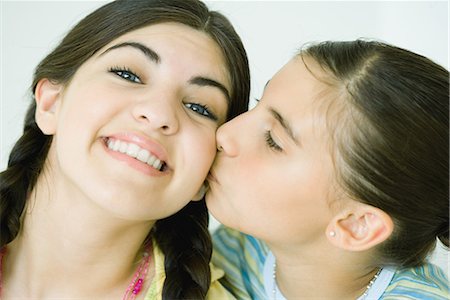 simsearch:695-03375998,k - Two young female friends, one kissing the other on the cheek Fotografie stock - Premium Royalty-Free, Codice: 696-03394064