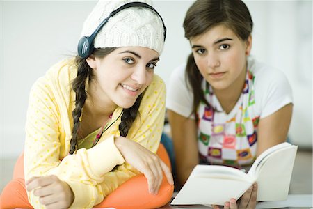 Two young female friends lying on floor, doing homework together Stock Photo - Premium Royalty-Free, Code: 696-03394089