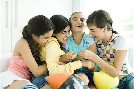 Four young female friends tickling each other and giggling Stock Photo - Premium Royalty-Free, Code: 696-03394102