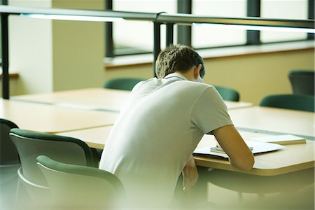 students working at library table - Male student studying, rear view Stock Photo - Premium Royalty-Free, Code: 696-03394257