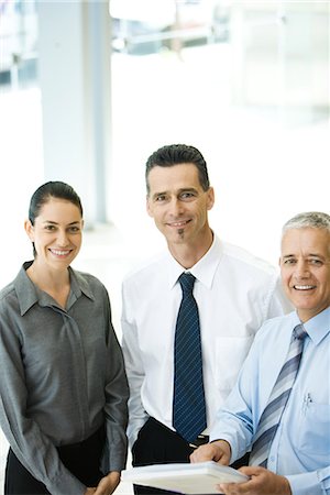 simsearch:632-01155400,k - Three business associates standing together, smiling at camera Foto de stock - Sin royalties Premium, Código: 696-03394307