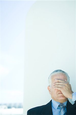 desperate - Mature businessman, hand covering eyes, head and shoulders Stock Photo - Premium Royalty-Free, Code: 696-03394327