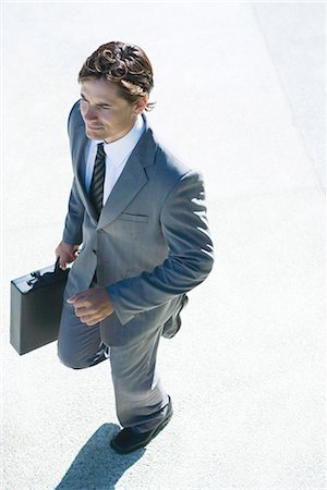 simsearch:632-01271843,k - Young businessman walking outdoors, carrying briefcase, high angle view Stock Photo - Premium Royalty-Free, Code: 696-03394338