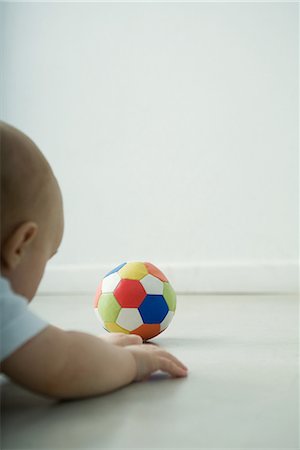 simsearch:632-01636989,k - Baby lying on floor, looking at ball Stock Photo - Premium Royalty-Free, Code: 696-03394555