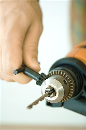 Man tightening drill bit, close-up of hand and drill Foto de stock - Sin royalties Premium, Código: 696-03394565