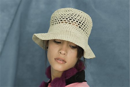simsearch:696-03394582,k - Teenage girl wearing sun hat, looking down, portrait Foto de stock - Royalty Free Premium, Número: 696-03394588
