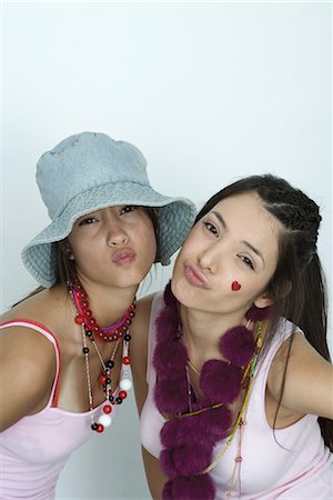 simsearch:695-03376668,k - Two young female friends wearing lots of accessories, puckering at camera, portrait Stock Photo - Premium Royalty-Free, Code: 696-03394630