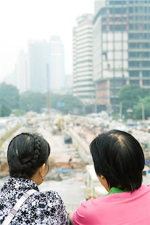 simsearch:632-01784591,k - China, Guangdong Province, Guangzhou, two people looking out over construction site, rear view, close-up Foto de stock - Sin royalties Premium, Código: 696-03394900