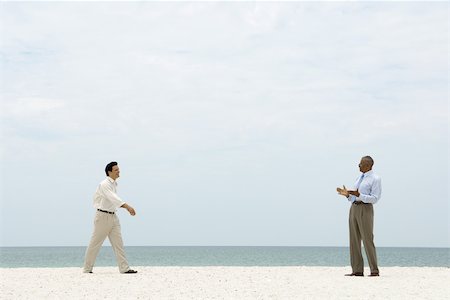 simsearch:696-03395223,k - Two businessman walking toward each other on the beach, both smiling Foto de stock - Sin royalties Premium, Código: 696-03395091