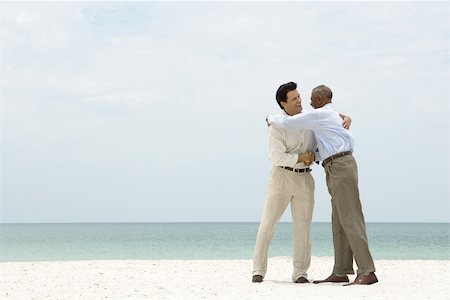 simsearch:696-03395223,k - Two businessmen shaking hands and embracing on the beach Foto de stock - Sin royalties Premium, Código: 696-03395092