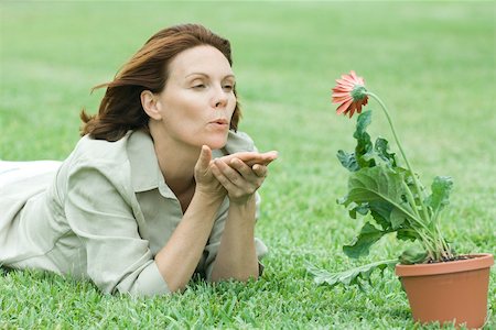 Femme couchée sur l'herbe, souffle un baiser au gerbera daisy Photographie de stock - Premium Libres de Droits, Code: 696-03395259