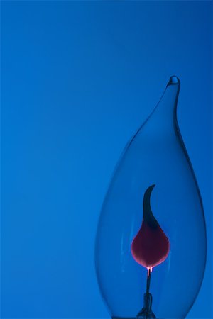 flame not people not cooking - Lightbulb against blue background, close-up Stock Photo - Premium Royalty-Free, Code: 696-03395588