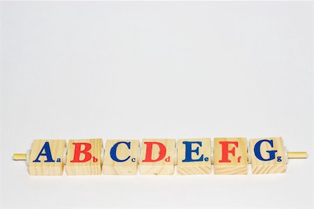 d - Wooden alphabet blocks in a row, close-up Foto de stock - Royalty Free Premium, Número: 696-03395606