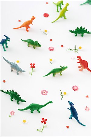 Plastic dinosaurs surrounded by fake flowers, high angle view Stock Photo - Premium Royalty-Free, Code: 696-03395811