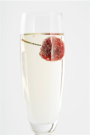 simsearch:695-03389882,k - Glass of champagne with a cherry floating in it, close-up Stock Photo - Premium Royalty-Free, Code: 696-03395984