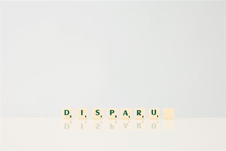 disappearing - Word game tiles spelling the word "Disparu," ("disappeared" in french), with final tile blank Stock Photo - Premium Royalty-Free, Code: 696-03396015