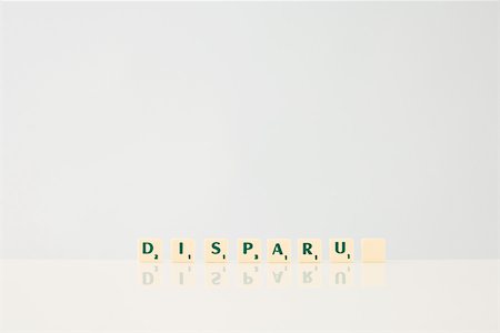 simsearch:696-03396044,k - Word game tiles spelling the word "Disparu," ("disappeared" in french), with final tile blank Stock Photo - Premium Royalty-Free, Code: 696-03396015