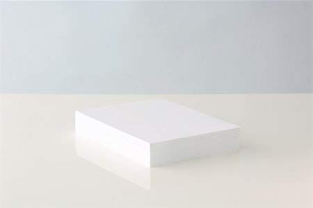 Stack of blank paper resting on table Stock Photo - Premium Royalty-Free, Code: 696-03396017