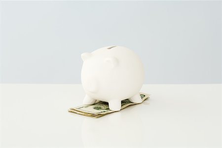 pig bank - Piggy bank on top of a small pile of twenty dollar bills Foto de stock - Sin royalties Premium, Código: 696-03396045