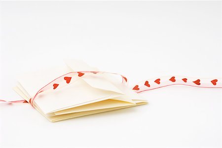 Love letter tied with heart ribbon Stock Photo - Premium Royalty-Free, Code: 696-03396093