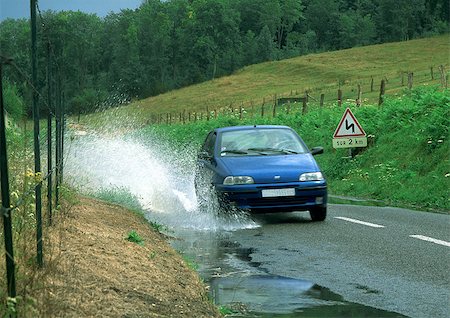 puddle road - Car driving through puddle, splashing water Stock Photo - Premium Royalty-Free, Code: 696-03396920