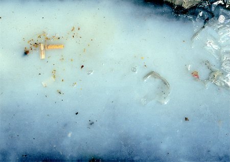 Mégot de cigarette dans l'eau rue sale. Photographie de stock - Premium Libres de Droits, Code: 696-03397347