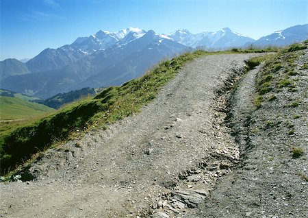 simsearch:696-03398019,k - France, Alpes, dirt uphill road with snow-covered mountains in background Foto de stock - Sin royalties Premium, Código: 696-03397460