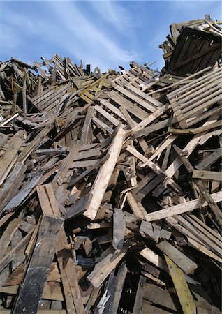 Large heap of wooden planks and pallets, blue sky in background Stock Photo - Premium Royalty-Free, Code: 696-03398438