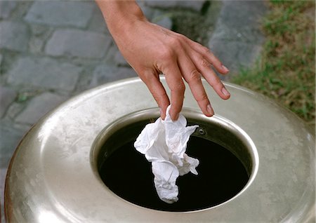 Person throwing piece of trash into garbage can Stock Photo - Premium Royalty-Free, Code: 696-03398474