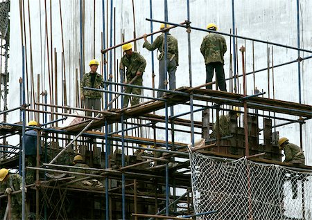 photo of civil engineering scaffolding - Workers with hard hats, standing on scaffolding Stock Photo - Premium Royalty-Free, Code: 696-03398551