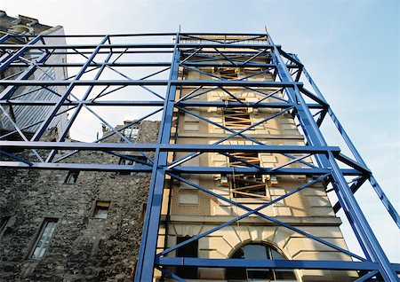 Scaffolding against building fronts, low angle view Stock Photo - Premium Royalty-Free, Code: 696-03398564