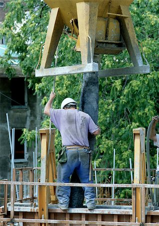 simsearch:696-03398634,k - Construction worker holding pipe under cement mixer, rear view Foto de stock - Sin royalties Premium, Código: 696-03398596