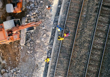 Men wearing hard hats, standing on rails, elevated view Stock Photo - Premium Royalty-Free, Code: 696-03398590