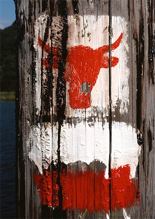 Bull's head symbol painted on wooden post Stock Photo - Premium Royalty-Free, Code: 696-03398851