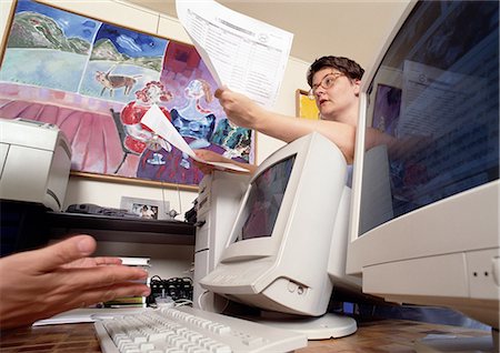 rebuking - Femme s'appuyant sur l'écran de l'ordinateur, munies de documents, vue d'angle faible Photographie de stock - Premium Libres de Droits, Code: 696-03398878