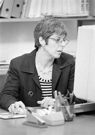 Femme assise devant un ordinateur, b&w Photographie de stock - Premium Libres de Droits, Code: 696-03398901