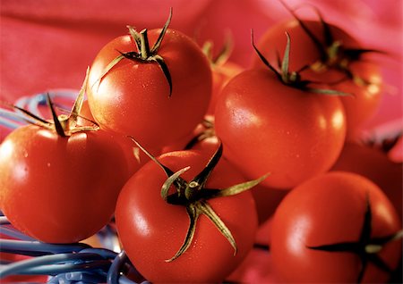 simsearch:633-01715311,k - Pile of red tomatoes with green stems, close-up Foto de stock - Sin royalties Premium, Código: 696-03398916