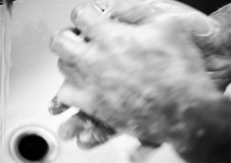 simsearch:633-02044482,k - Hands covered in soap suds over sink, blurred, b&w Foto de stock - Royalty Free Premium, Número: 696-03399311