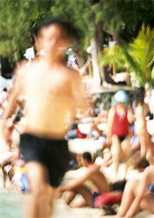 sunbathing crowd - Bare-chested person running, people in background on beach, blurred Stock Photo - Premium Royalty-Free, Code: 696-03399487