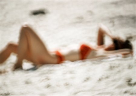 sunbathing crowd - Woman in swimming suit, lying on sand, blurred Stock Photo - Premium Royalty-Free, Code: 696-03399517