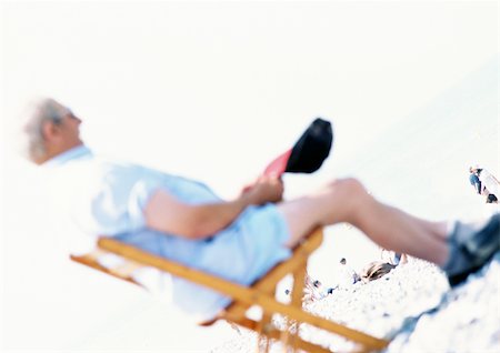 simsearch:696-03399615,k - Personne assise dans une chaise de plage, floue Photographie de stock - Premium Libres de Droits, Code: 696-03399617