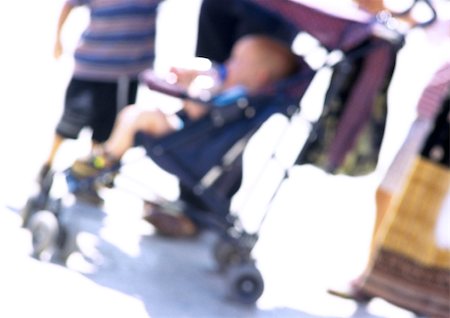 Child in stroller with group of people, blurred Stock Photo - Premium Royalty-Free, Code: 696-03399624