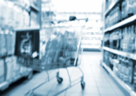 Shopping cart in aisle of supermarket, blurred Foto de stock - Royalty Free Premium, Número: 696-03399955