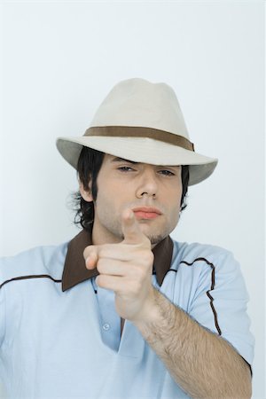 rebuking - Young man wearing hat, pointing at camera Stock Photo - Premium Royalty-Free, Code: 696-03393936