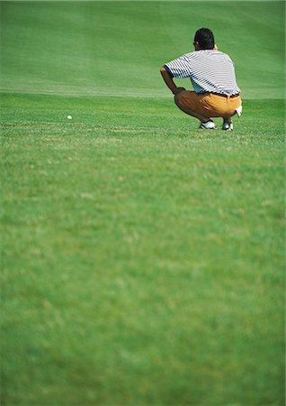 simsearch:632-01153250,k - Golfer crouching on green, rear view Stock Photo - Premium Royalty-Free, Code: 696-03400059