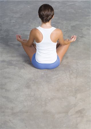 Woman sitting in lotus position on floor Stock Photo - Premium Royalty-Free, Code: 696-03400129