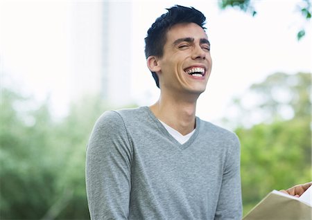 simsearch:632-03027019,k - Young man reading book and laughing in urban park Stock Photo - Premium Royalty-Free, Code: 696-03400178