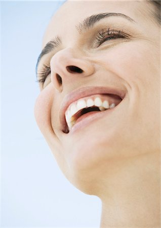 simsearch:695-03388489,k - Woman smiling, low angle view Fotografie stock - Premium Royalty-Free, Codice: 696-03400323