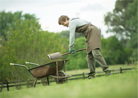 simsearch:673-06964904,k - Homme pelleter la saleté dans la brouette Photographie de stock - Premium Libres de Droits, Code: 696-03400352